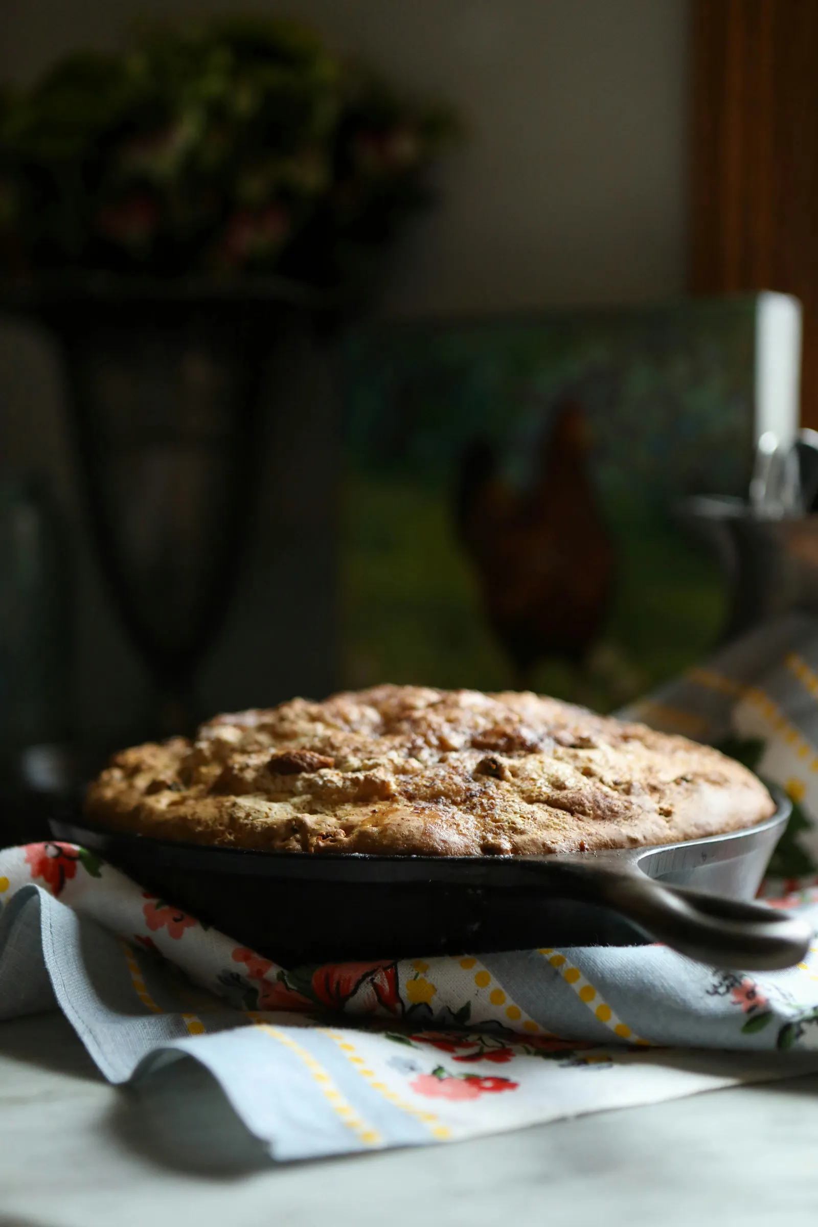 A cast iron skillet of golden, freshly baked cornbread on a country kitchen counter