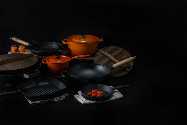 A lineup of cast iron skillets and a dutch oven, the cookware compared in this cast iron vs stainless steel guide